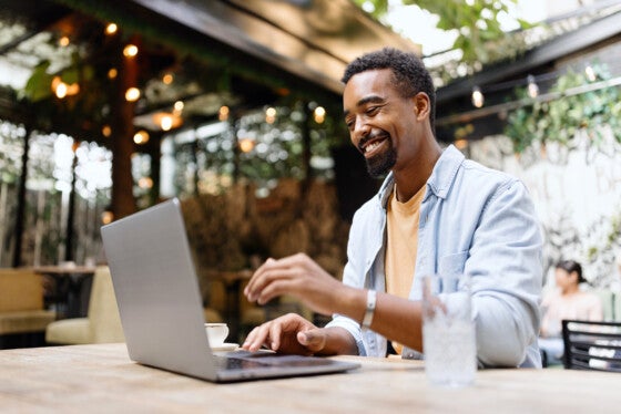 Black man working on a laptop at the cafe