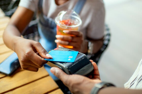 Young woman paying with credit card in a cafe