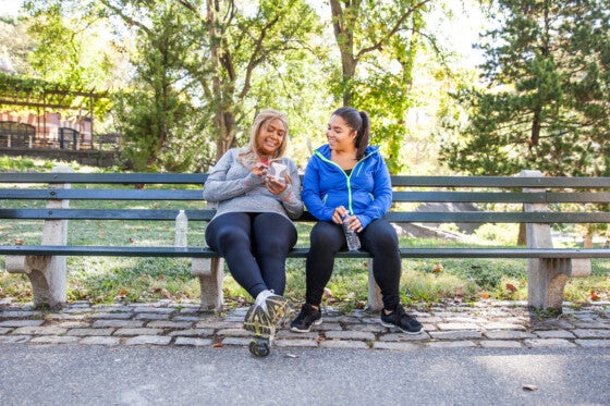 Women taking a break from exercising on park bench