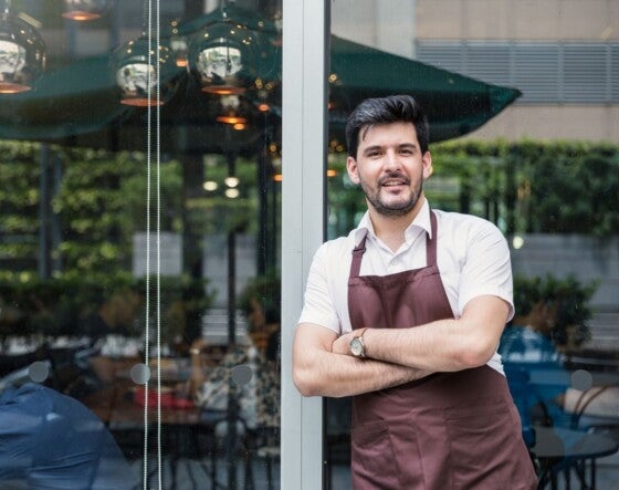 Startup successful small business owner man walking in his coffee shop or restaurant. Portrait of young caucasian man successful barista cafe owner