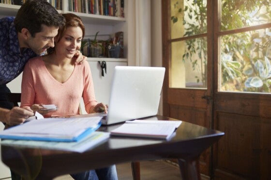 Couple working through taxes forms at home.Lifestyle shot in real location, Spain. Husband is Spanish and wife is Polish.