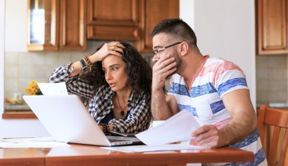 Young woman sitting at home in casual clothes and reviewing home finances