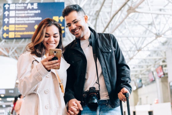 Couple using smartphone at the airport