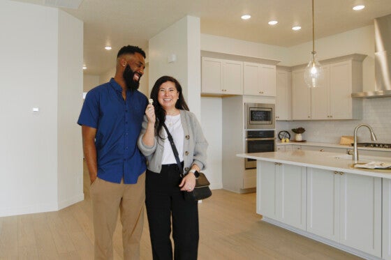 New home buying couple celebrating in their new home.